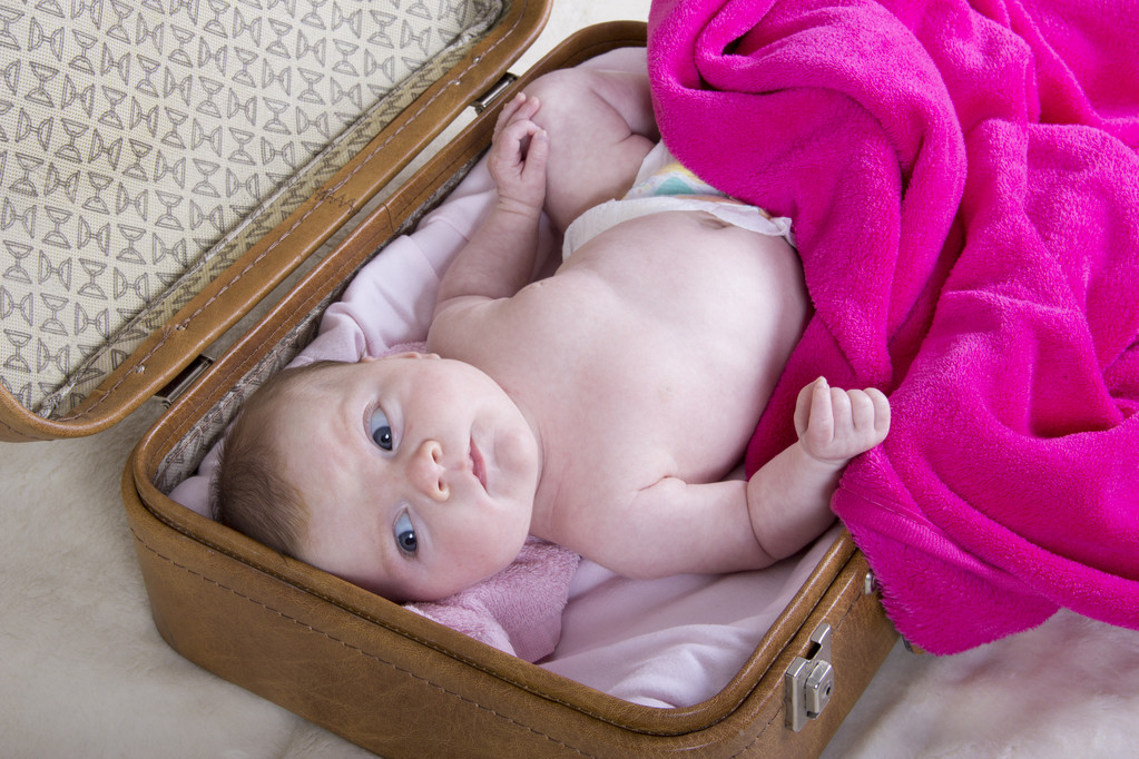 baby girl in vintage suitcase